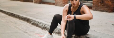 Laufschuhe und Fitnessuhr auf dem Boden